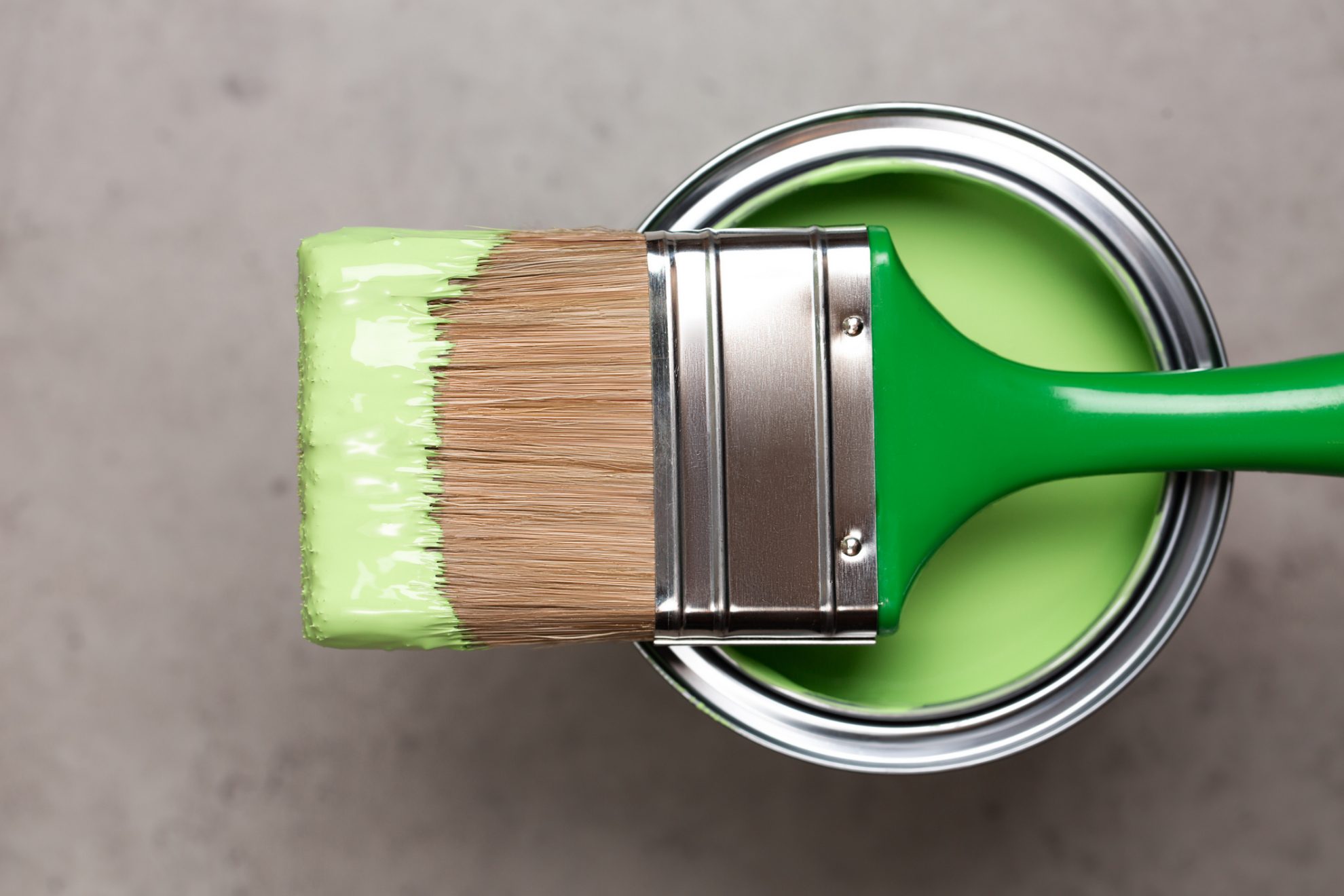 Paintbrush on paint pot  with green pigment for Redecoration concept in home interior. 
